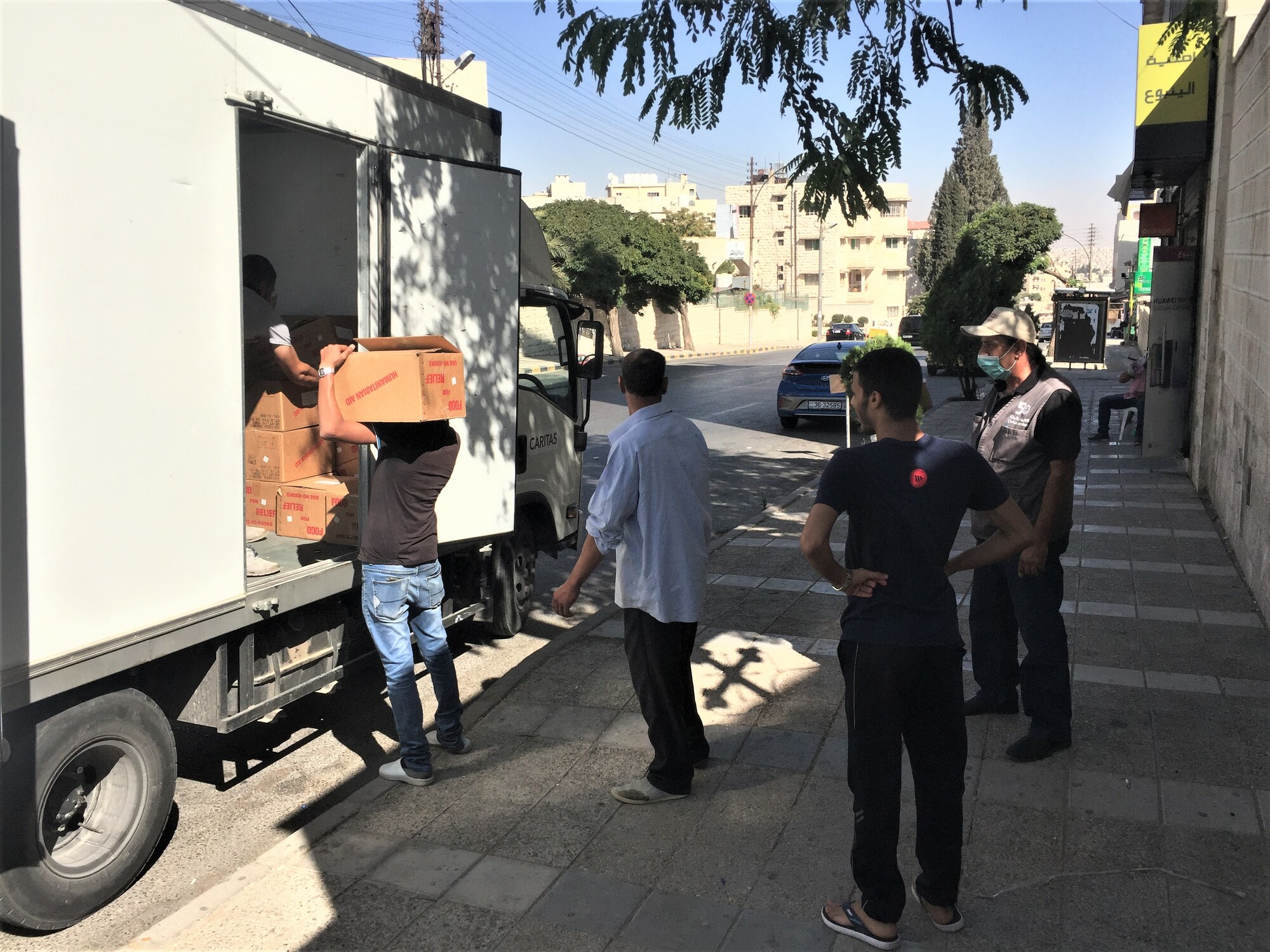 Several people unload boxes from a truck in Jordan